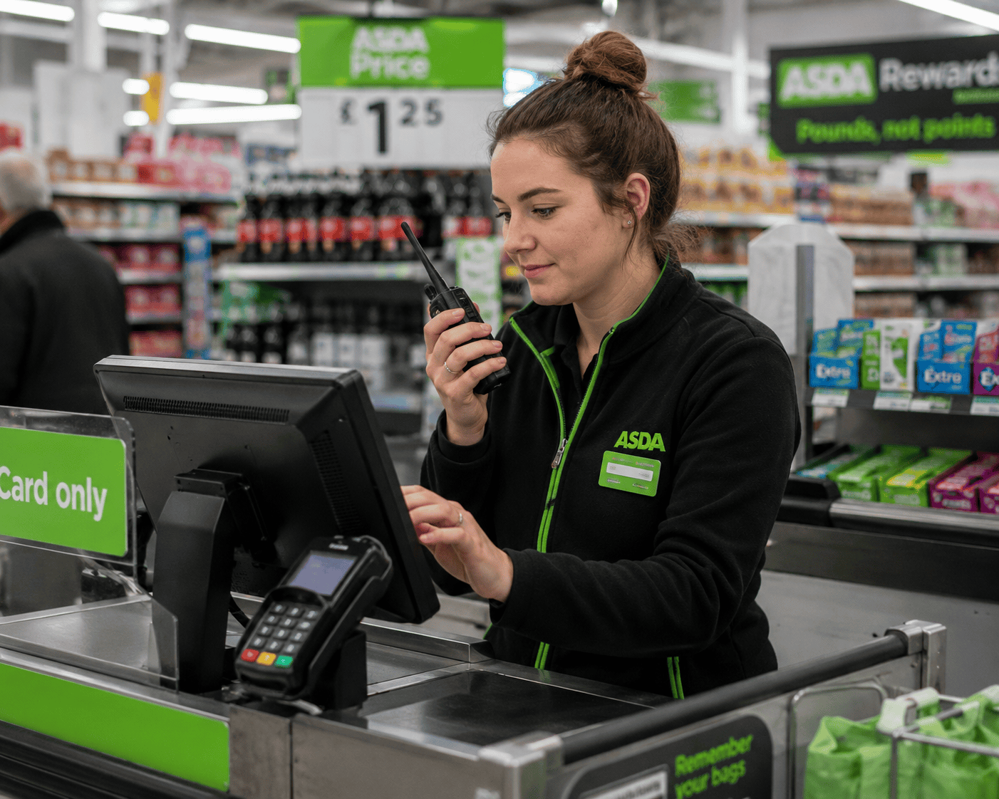 Checkout at ASDA supermarket station Theme park worker at bustling attraction