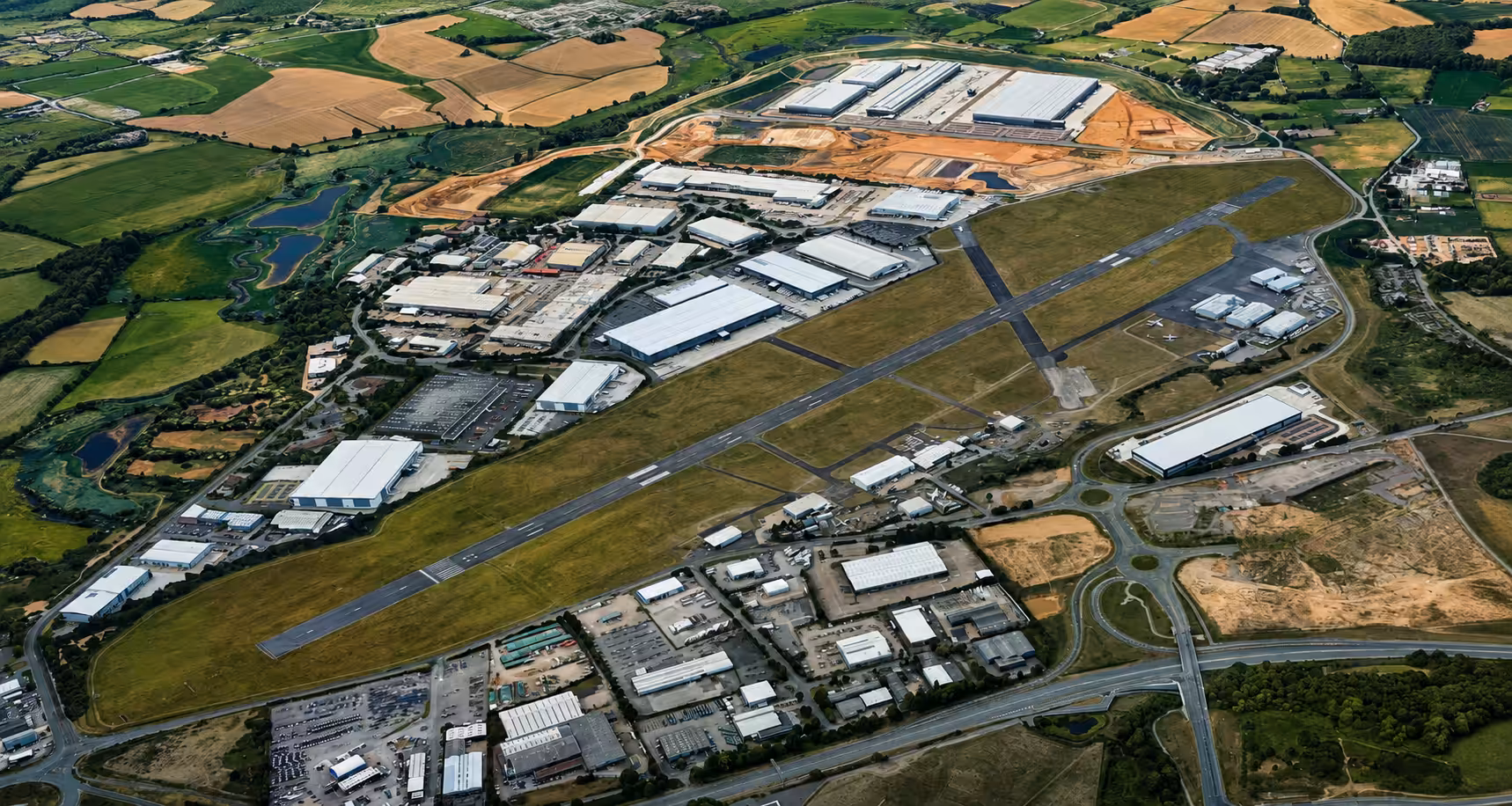 Aerial view of Coventry Airport with runways and surrounding industrial area.